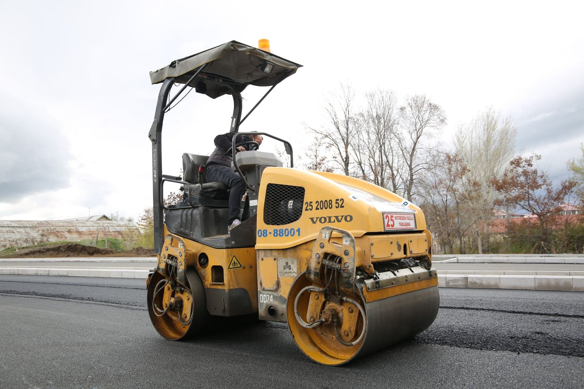 Roller compacting a freshly paved asphalt surface